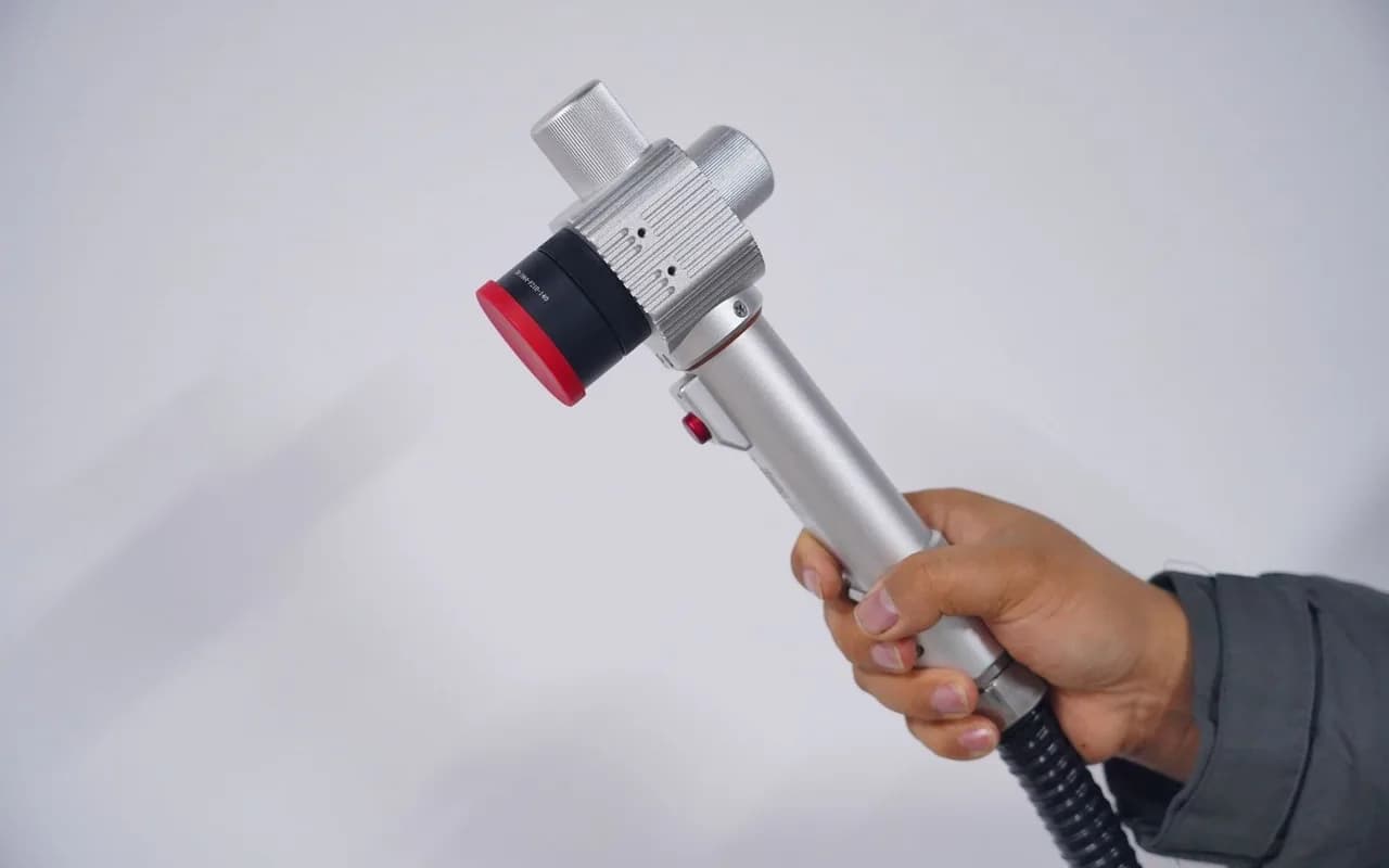 Pistolet de nettoyage au laser tenu en main pour le décapage sans contact d'une surface métallique.